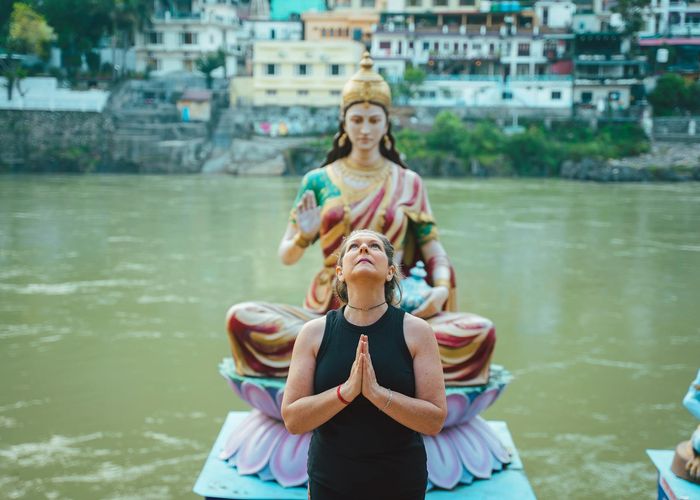 Person meditating outdoors with a serene natural background.